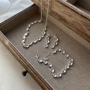 Elegantes S925 Sterlingsilber Schmuckset mit unregelmäßigen Kieselformen in Holztablett