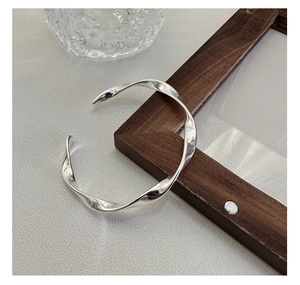 Detailed view of the S925 sterling silver stamp on minimalist twisted bangle bracelet