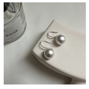 Macro detail of minimalist S925 sterling silver ball drop earrings with matte finish