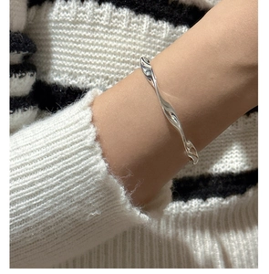 Detailed close-up of S925 sterling silver wave textured bracelet worn on wrist