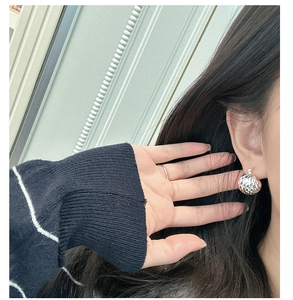 Detail showing S925 sterling silver laser cut earring and minimalist ring worn by a model