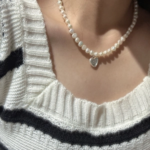 Collier en perles d'argent S925 avec pendentif cœur minimaliste porté par un mannequin