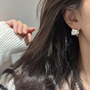 Polished S925 sterling silver chunky C-shaped hoop earrings on model with white sweater