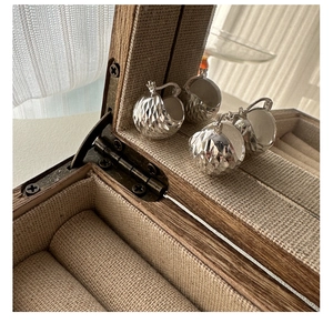 Detailed view of silver hoop earrings with diamond-cut texture in a jewelry box