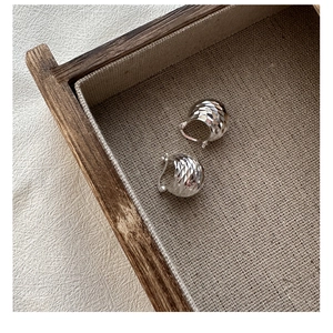 Detailed macro view of S925 sterling silver hoop earrings with diamond-cut faceted texture