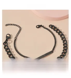 Detail of two black stainless steel curb and cross chains with customizable metal tags