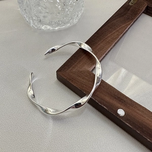 Elegant S925 sterling silver twisted wave open bangle shown from a 45-degree angle