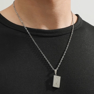 Fashionable silver envelope pendant necklace worn by a model on a black t-shirt