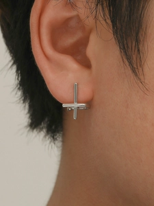 Close-up of a silver cross geometric stud earring worn on the ear for a modern look