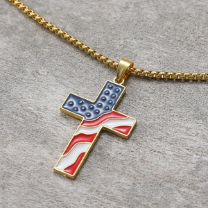 Detail of USA flag cross pendant in gold finish with blue enamel and red stripes