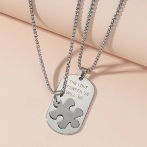 Minimalistische Edelstahl Puzzle-Anhänger Halsketten für Paare auf rosa Hintergrund