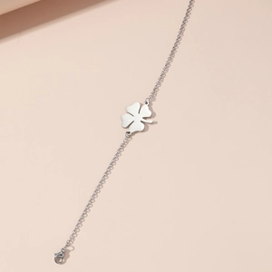 Detailed close-up of lucky four-leaf clover pendant on a polished stainless steel chain