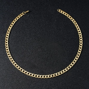 Detail van gouden cubaanse schakelketting met karabijnsluiting op zwarte achtergrond