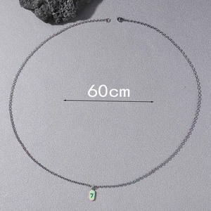 Detailed view of the 60cm rainbow plated chain and number 7 pendant on a stone background