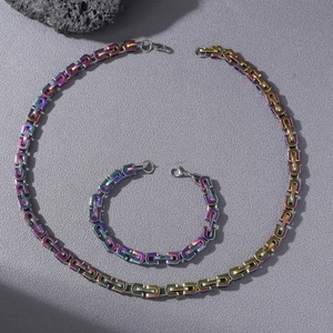 Parure collier et bracelet byzantins en acier inoxydable arc-en-ciel sur fond de pierre