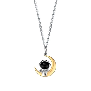 Détail du pendentif astronaute avec lune dorée sur une fine chaîne argentée