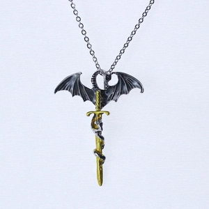 Detail of gothic golden sword necklace with a black dragon wrapped around the hilt