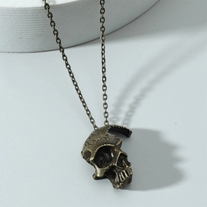 Vue rapprochée du pendentif tête de mort gothique en bronze sur support blanc
