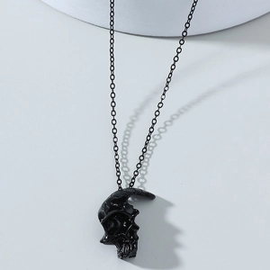 Détail d'un pendentif demi-crâne gothique avec finition noire brillante sur chaîne