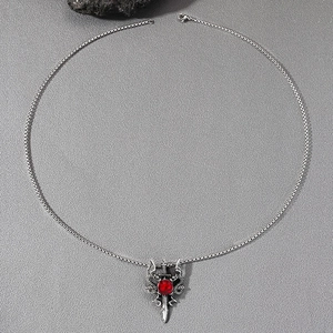 Gothic sword necklace with double dragon relief and ruby gemstone on grey background