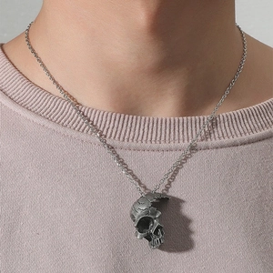 Détail du pendentif crâne gothique demi-visage avec texture métal vintage sur une chaîne