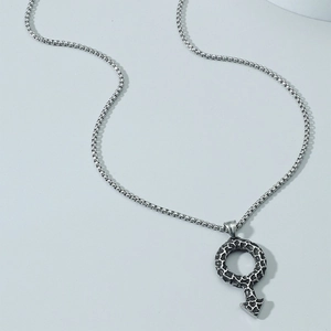 Detailed macro view of vintage silver Mars symbol pendant with textured crater surface