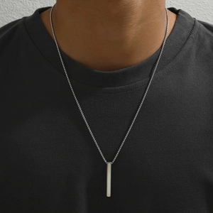 Close-up of minimalist rectangular stainless steel bar pendant on a silver box chain