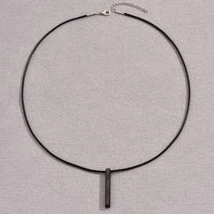 Detail of minimalist matte black rectangular pendant with adjustable black cord necklace