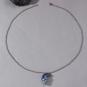Detailaufnahme der regenbogenfarbenen Gothic Totenkopf Halskette auf schwarzem Stein