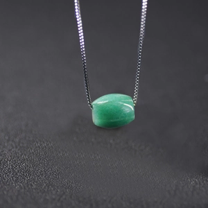 Gros plan d'un pendentif en aventurine verte sur une chaîne de boîte en argent