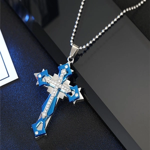 Détail d'un pendentif croix bleu et argent à plusieurs couches avec strass sur chaîne à billes