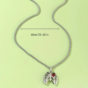 Détail macro du pendentif cage thoracique avec cœur rouge et chaîne de 60 cm