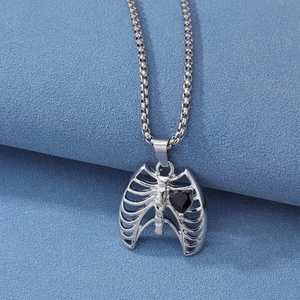 Collier cage thoracique avec pendentif coeur noir sur fond bleu au style gothique