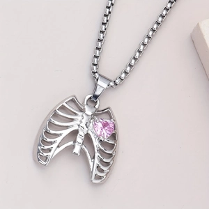 Vue macro du pendentif cage thoracique en argent avec cœur en zircon rose sur chaîne