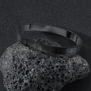Macro detail of black brushed stainless steel bracelet with Roman numeral engravings