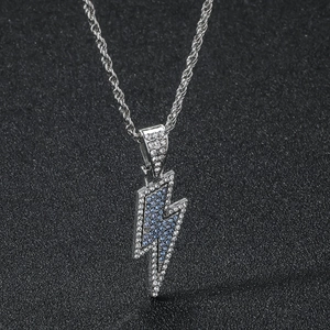 Dettaglio macro del ciondolo a fulmine con cristalli blu e trasparenti su catena d'argento