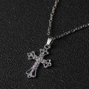 Sleek silver hollow cross pendant necklace with sparkling diamonds on black background