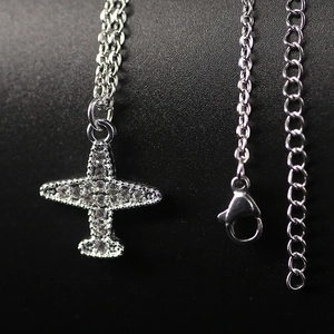 Glittering airplane pendant necklace with crystal zircons on a silver link chain