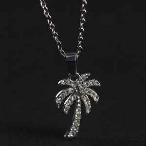 Glittering coconut tree necklace with white zircons for women on a dark background