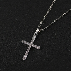 Collier croix en argent classique avec pavé de cristaux brillants sur fond noir mat