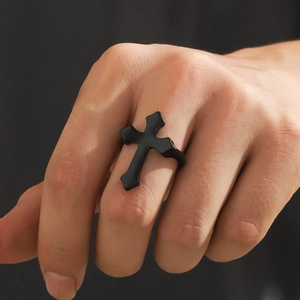 Detailed view of a black gothic cross open ring worn on a male finger in matte finish