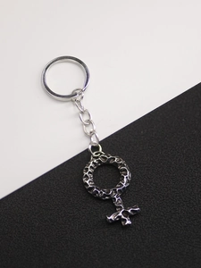 Macro shot of vintage Viking gender symbol keychain with textured antique silver finish