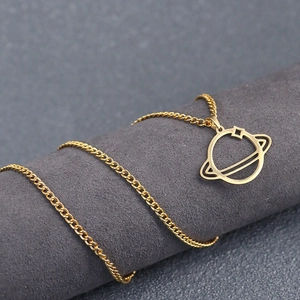 Minimalist gold planet saturn pendant necklace with hollowed ring on grey display stand