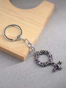 Macro detail of vintage silver viking symbol keychain with textured cross and ring pendant
