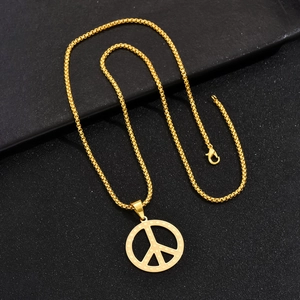 Collier avec pendentif signe de la paix doré et chaîne carrée sur fond noir