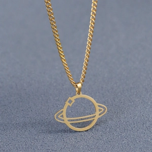 Macro view of gold planet Saturn pendant with cutout design on classic curb chain