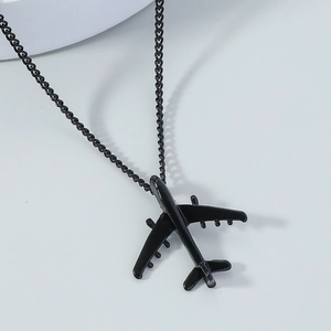 Macro detail of matte black airplane pendant necklace with smooth metallic wings
