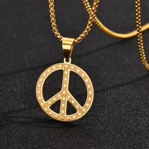 Macro du pendentif signe de paix doré avec points en relief sur fond noir