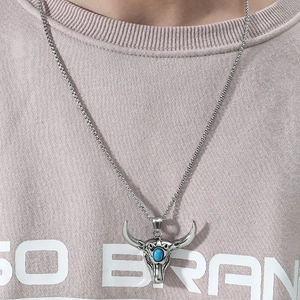 Dettaglio del ciondolo testa di bue vintage con pietra turchese su catena a maglia