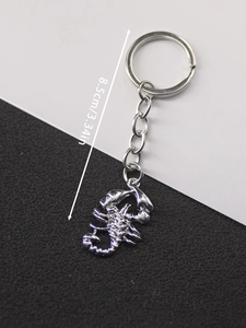 Detail view of a vintage scorpion keychain with 8.5cm length measurement on black background